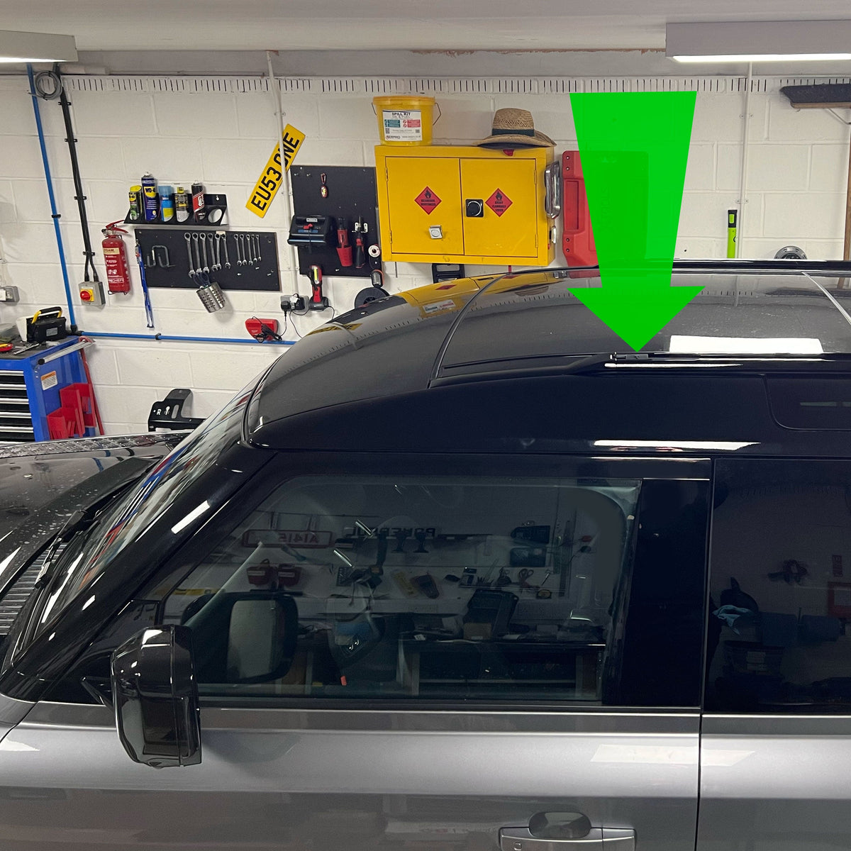 AirTag holder installed in a Defender L663 roof rail; arrow indicates location